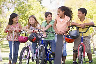 Friends with bicycles scooters and skateboard