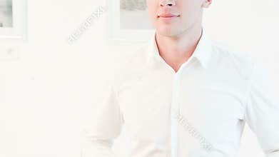 Smiling man buttoning up to neck white shirt