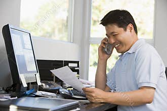 Man in home office with computer and paperwork