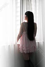 Asia girl standing by the window