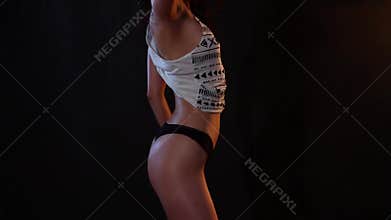 brunette woman in black bikini and white shirt dancing