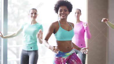 Group of smiling people dancing in gym or studio