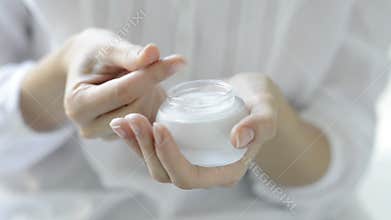 Beautiful woman hands applying moisturizer