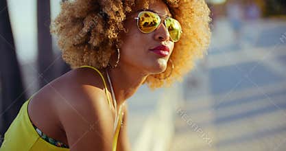 Sensual Girl with Afro Resting on Promenade