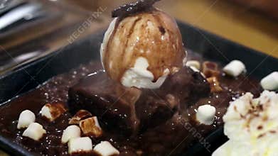 Marshmallow and ice cream waffle with melt hot chocolate topping pour on hot plate