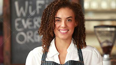 Smiling barista handing two cups of coffee