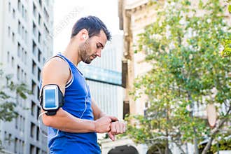 Handsome athlete setting heart rate watch