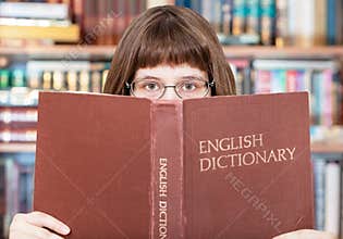 Girl looks over English Dictionary in library