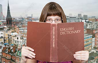 Girl looks over English Dictionary and skyline