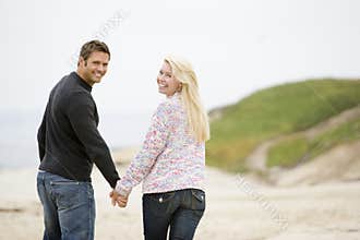 Couple walking at beach holding hands