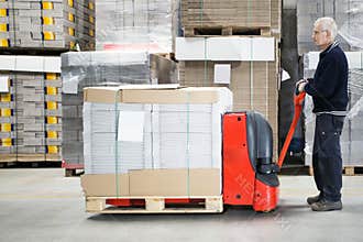 Worker With Loaded Handtruck In Warehouse