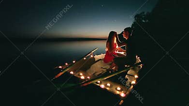 Young love romance on boat with candles at night
