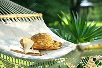Hammock, book, hat, and glasses on a sunny day