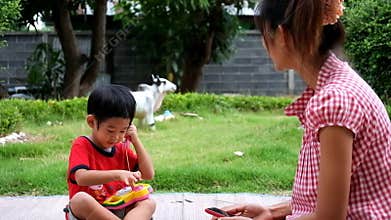 Boy is calling to mother with toy telephone