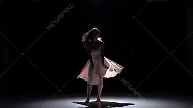 Modern dancer girl in white dress dancing contemporary, jumps on black, shadow, slow motion