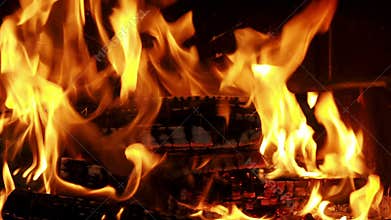 Wood burning in the fireplace with a fire iron