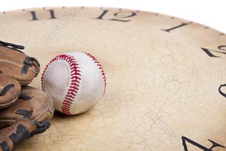 A baseball and mitt on an old vintage cloc