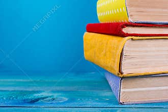Stack of colorful books, grungy blue background, free copy space
