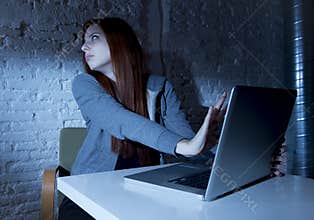 Scared female teenager with computer laptop suffering cyberbullying and harassment being online abused