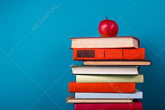 Stack of colorful books, grungy blue background, free copy space