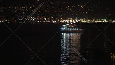 Touristic ship sailing along night city