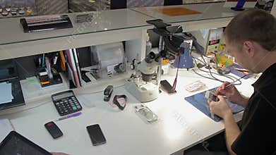 Man repairing a broken phone in the department of warranty