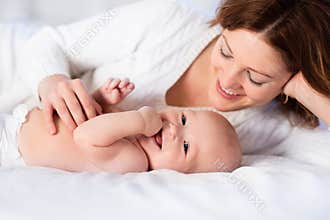 Mother and baby on a white bed