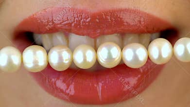 Close up of female lips and pearl bead. Dental concept.