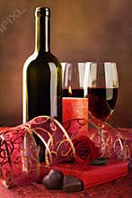 Red wine, candle and chocolate hearts, still life