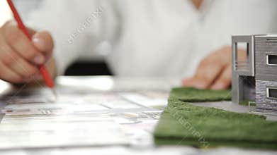 Engineer work on table with architecture model and white helmet. Close up. 4k