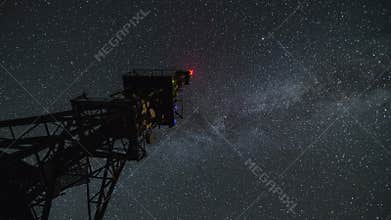 Communication tower in starry night time lapse. Moving stars sky with milky way galaxy. 4K