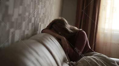 Depressed woman in bed. girl crying on the couch. acute mountain