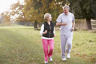 Senior Couple Power Jogging In The Park