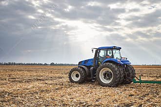 Tractor working in the field in autumn