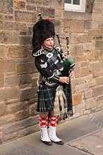Traditional Scottish bagpiper wearing kilt