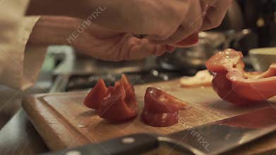 Male hands preparing paprika on a wooden cooking board