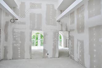 Unpainted interior of a new home under construction, showcasing unfinished drywall