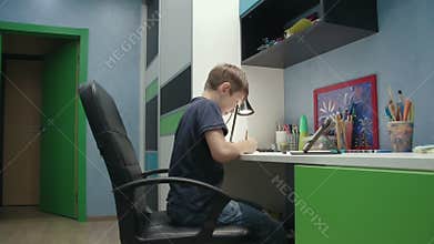 Young boy drawing a picture copying it from digital tablet
