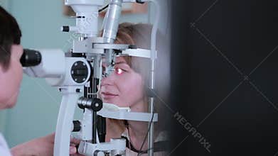 Ophthalmologist checks woman's eyes.