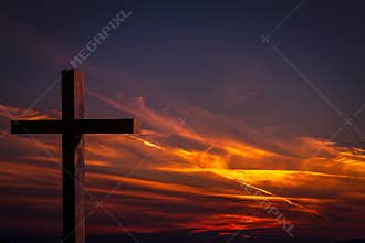 Jesus Christ wooden cross on a background with dramatic, colorful sunset, and orange, purple sky