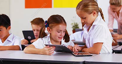 Students using digital tablet in classroom