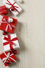 Christmas gifts presents on rustic wood background. Simple, red and white gift boxes festive holiday border.