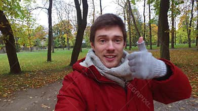 Man with smartphone taking video at autumn park