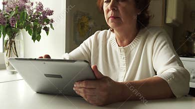 TRACKING: Aged woman using a digital tablet PC at home