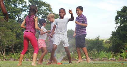 Kids playing with garden sprinkler