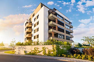 New modern block of flats in green area with blue sky