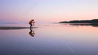 Landscape photographer on the coast line taking pictures of the sunset