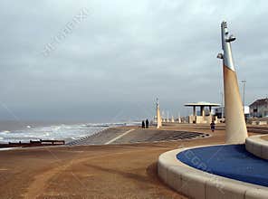 People on the promenade along the seafront at cleveleys in blackpool with steps leading to the beach