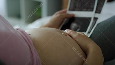 Video of pregnant woman stroking abdomen and browsing ultrasound images