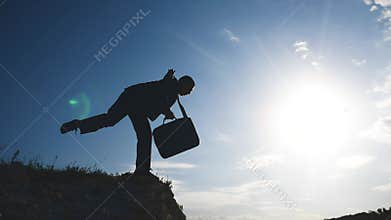 Business bankrupt crisis teamwork concept. Man businessman silhouette at sunset standing on the edge of the abyss peak